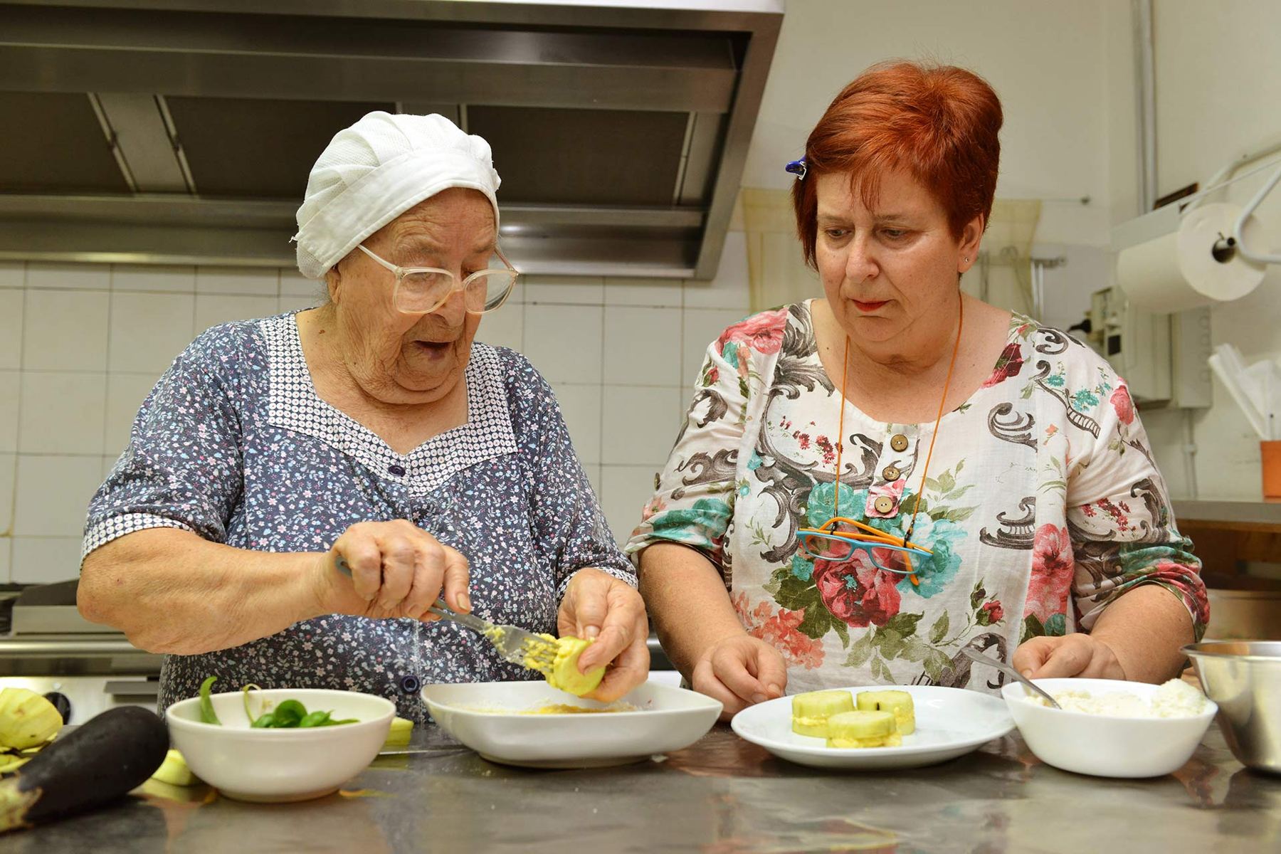 Zwei Frauen bereiten in einer Küche Gemüse zu.